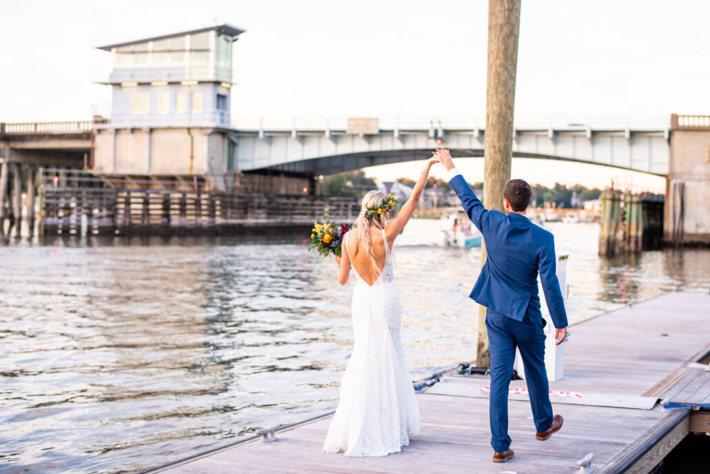 Bride and Groom walk on the dock of the Bluewater Waterfront Grill
